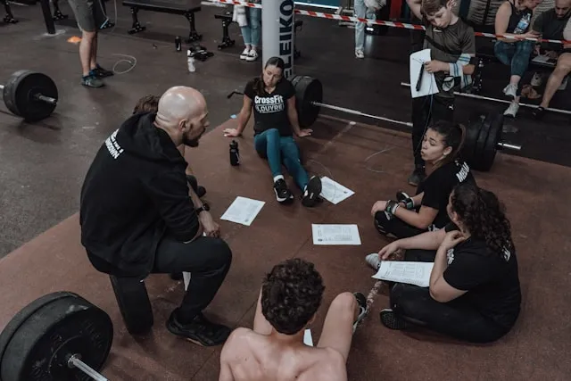 Un coach devant un groupe de jeunes athlètes.